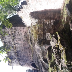 Une partie d'une tour basse restant du château et une partie d'un mur. Des pierres écroulées au sol